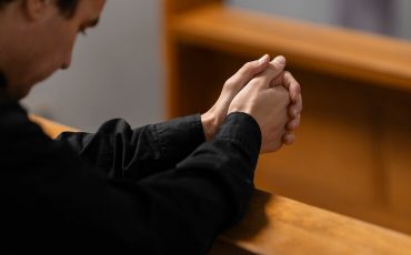 priest-praying-church-building_23-2151103976